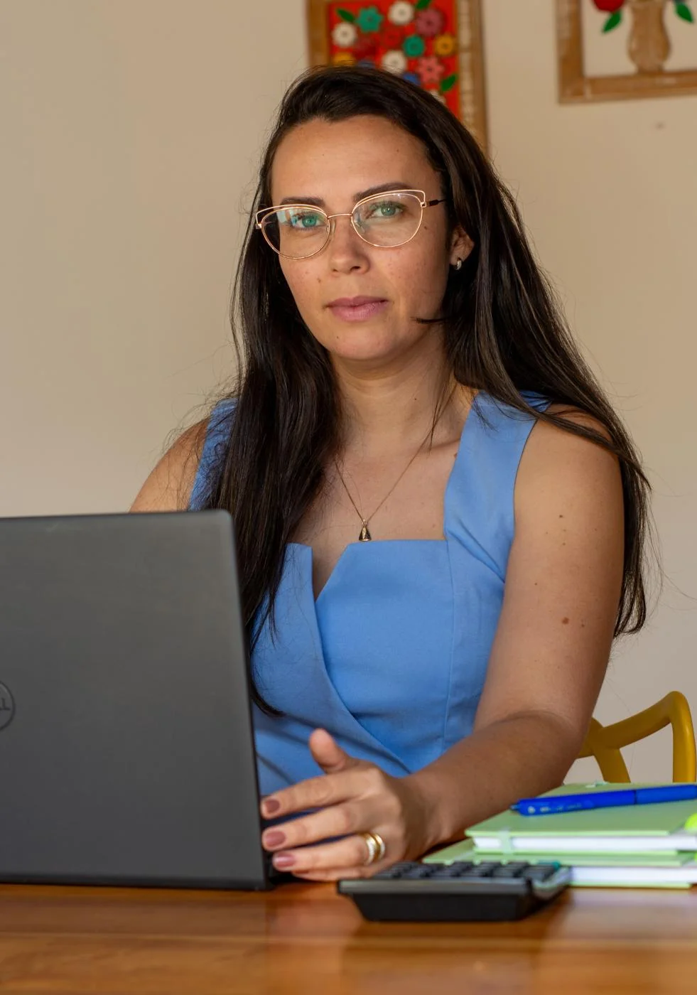 Persona adulta utilizando una computadora y una calculadora para organizar los gastos del hogar